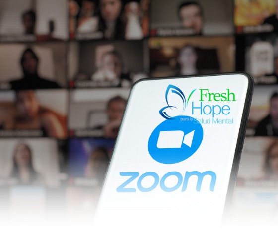 A phone showing the Zoom and Fresh Hope logos in front of a grid of video call participants