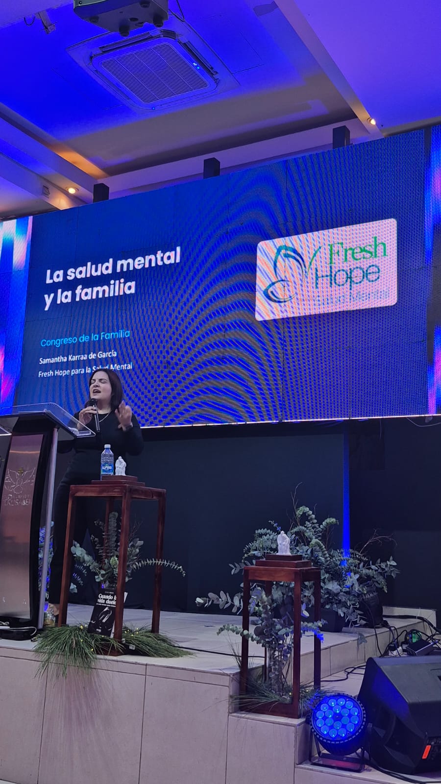 Samantha Karraa de García speaking at the Congreso de la Familia in front of a screen reading “La salud mental y la familia” with the Fresh Hope logo